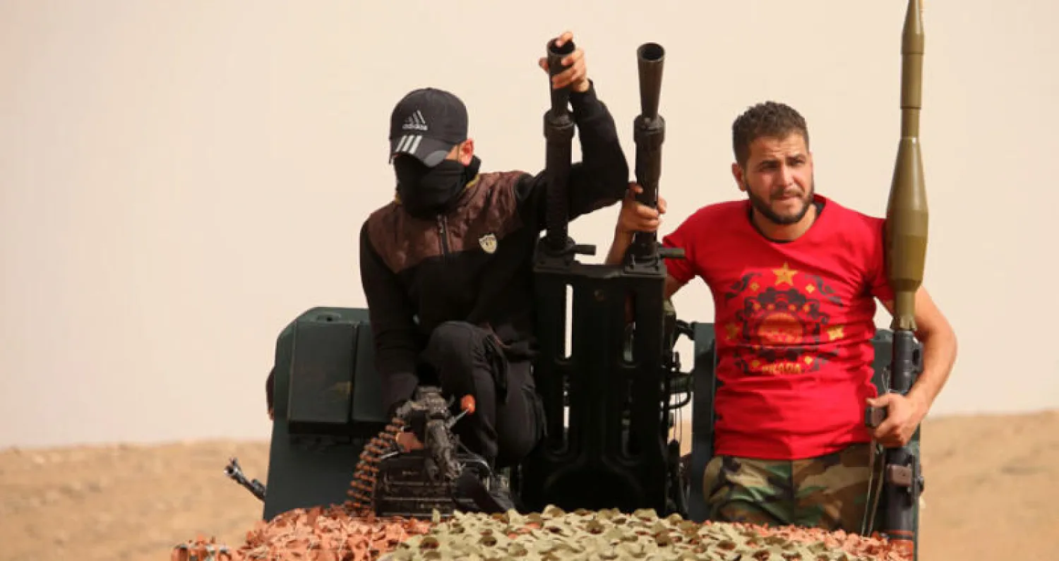 عناصر من ميليشيات المعارضة السورية يحملون أسلحة في عرض عسكري في درعا يونيو الماضي (أ.ف.ب)