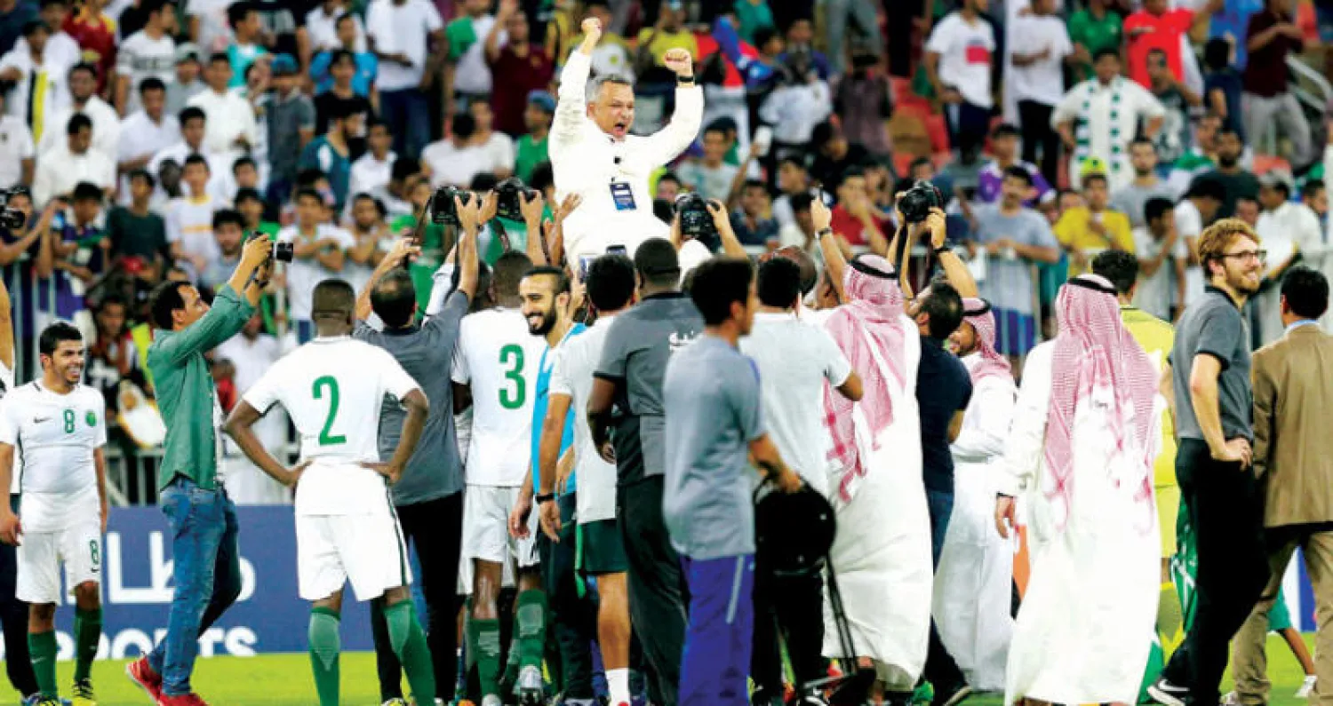 لاعبو المنتخب السعودي يرفعون عزت على الأعناق بعد التأهل للمونديال («الشرق الأوسط»)