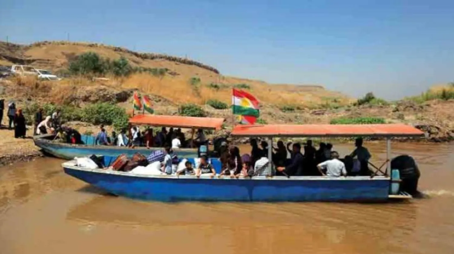 Kurdish families from Iraq traveling the Simalaka river crossing to Syria  (AFP)