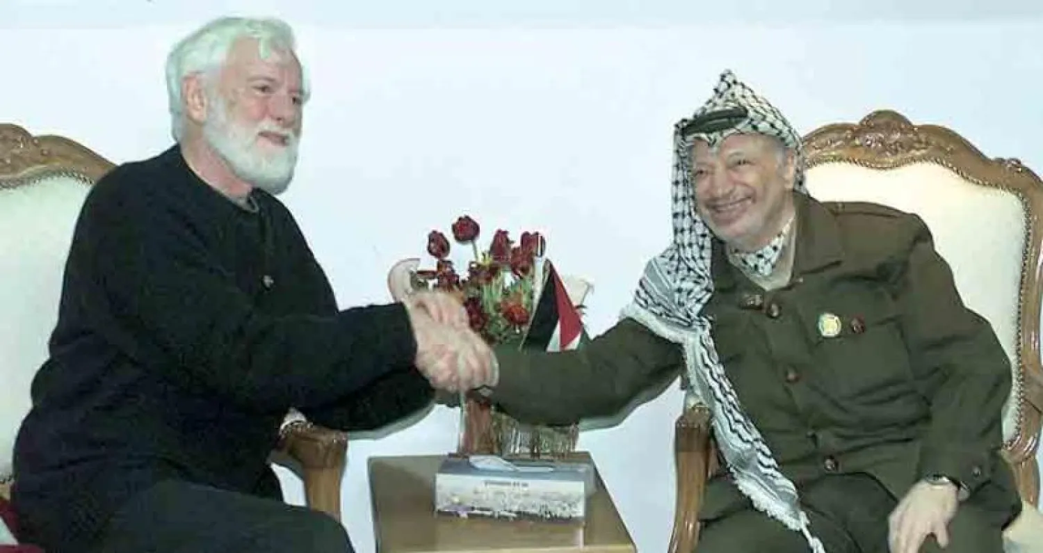 الرئيس الفلسطيني الراحل ياسر عرفات خلال استقباله ناشط السلام الإسرائيلي أوري أفنيري في رام الله في يناير 2002 (رويترز)