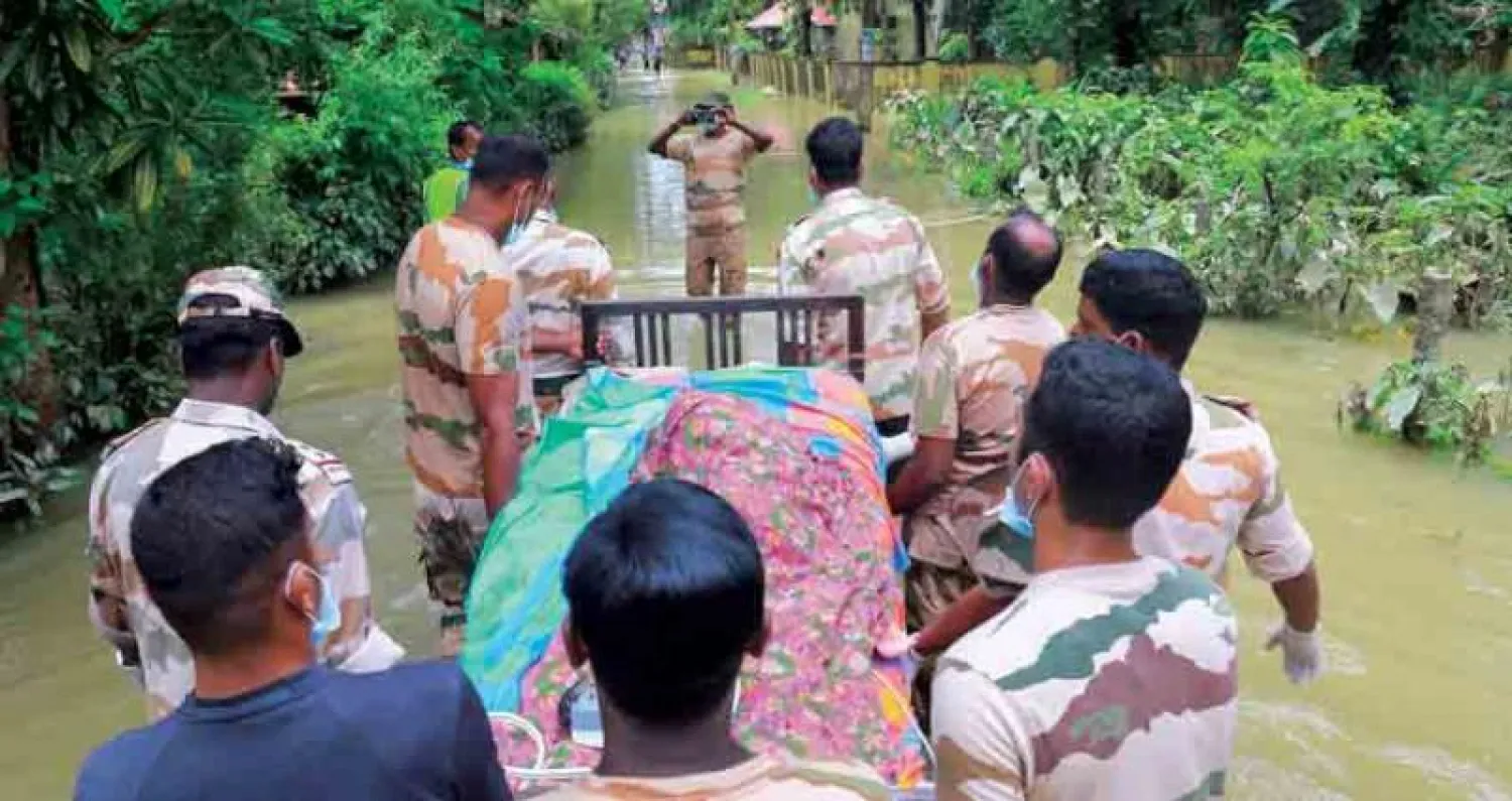 عاملو إنقاذ يجلون عجوزاً في شيناغانور أمس (أ.ف.ب)