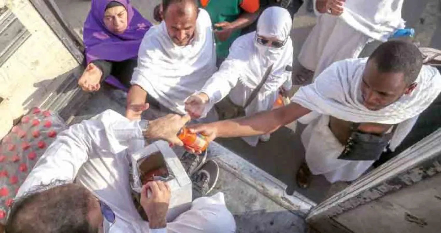 شاب سعودي يقدم عصائر مجانية للحجاج أمس في عرفات (تصوير: عبد الله الفالح)