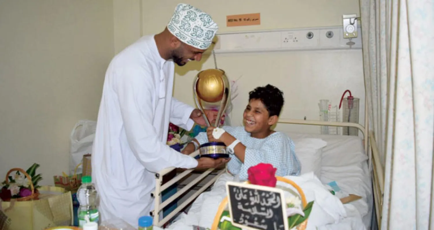 الحبسي خلال زيارته للطفل سعود العباد في أحد مستشفيات صلالة («الشرق الأوسط»)