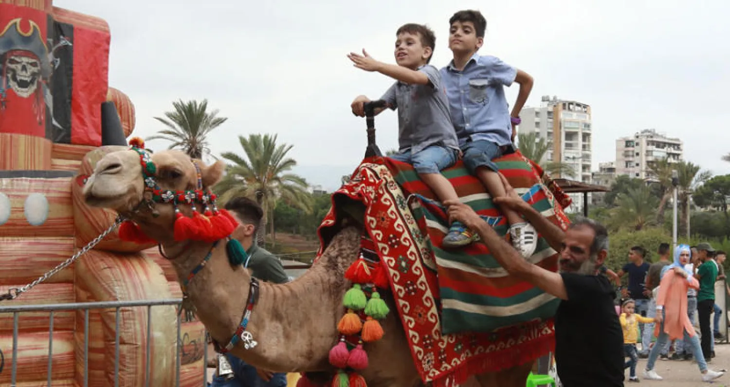 أطفال سوريون يقضون العيد في إحدى الحدائق العامة ببيروت (أ.ف.ب)