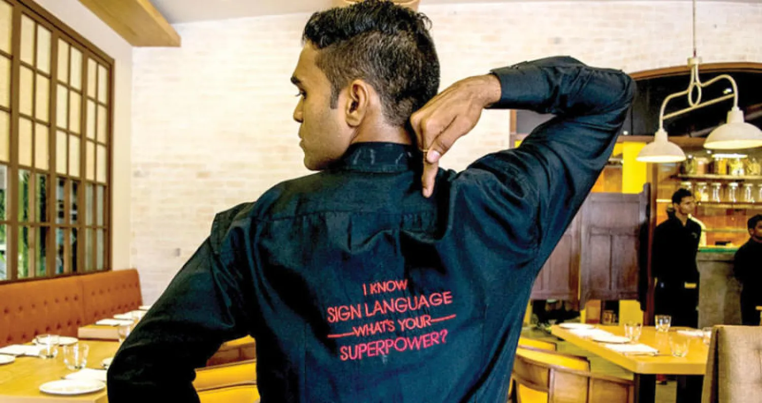 بعض العاملين يرتدي قمصاناً كُتب عليها «لغة الإشارة هي لغتي المميزة؟ ما هي لغتك؟»