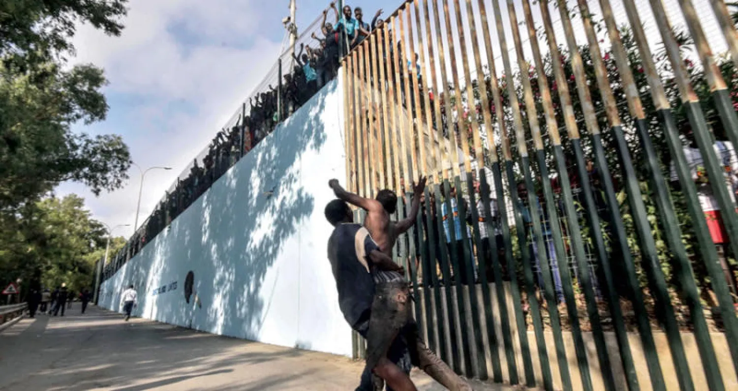 مهاجرون أفارقة يحاولون اقتحام السياج الحدودي المؤدي إلى جيب سبتة (أ.ف.ب)