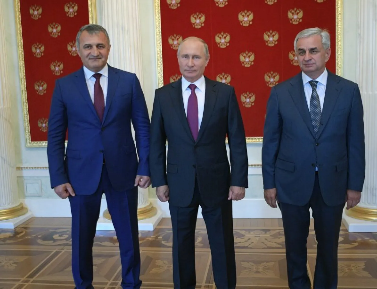 الرئيس الروسي فلاديمير بوتين بين رئيس أوسيتيا الجنوبية أناتولي بيبيلوف – إلى اليسار - ورئيس أبخازيا راوول خاجيمبا (إ. ب. أ)