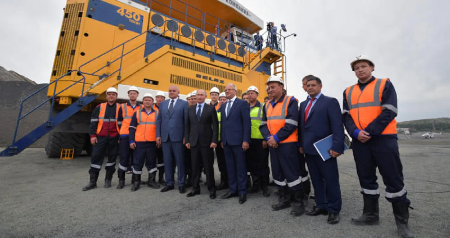 الرئيس الروسي فلاديمير بوتين يلتقط صورة تذكارية مع عمال منجم في كيميروفو (رويترز)