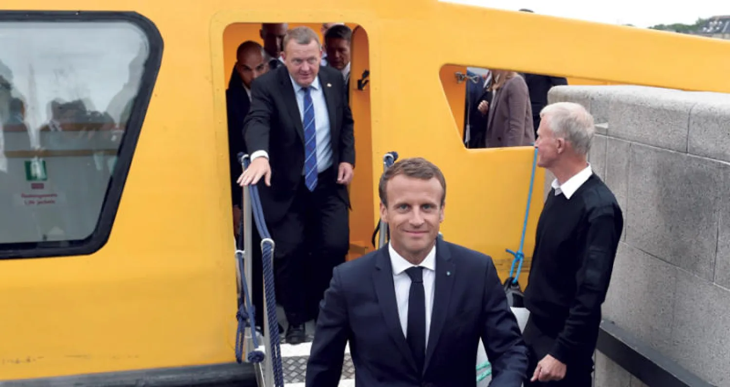 ماكرون ورئيس الوزراء الدنماركي عقب جولة على متن مركب في كوبنهاغن أمس (أ.ب)