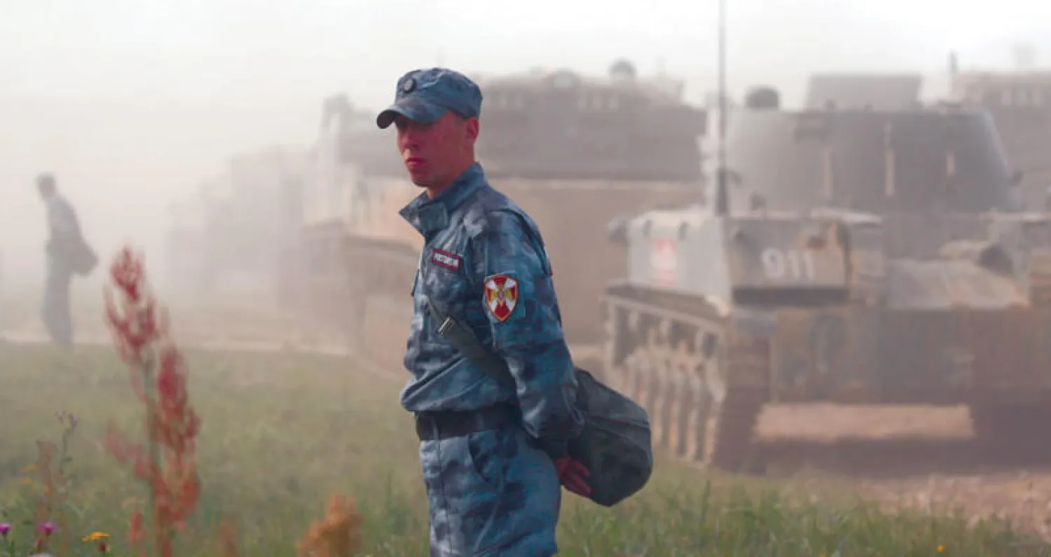 جندي من الحرس القومي الروسي بجانب مدرعة أثناء المنتدى العسكري الدولي السنوي في ألابينو خارج موسكو (رويترز)