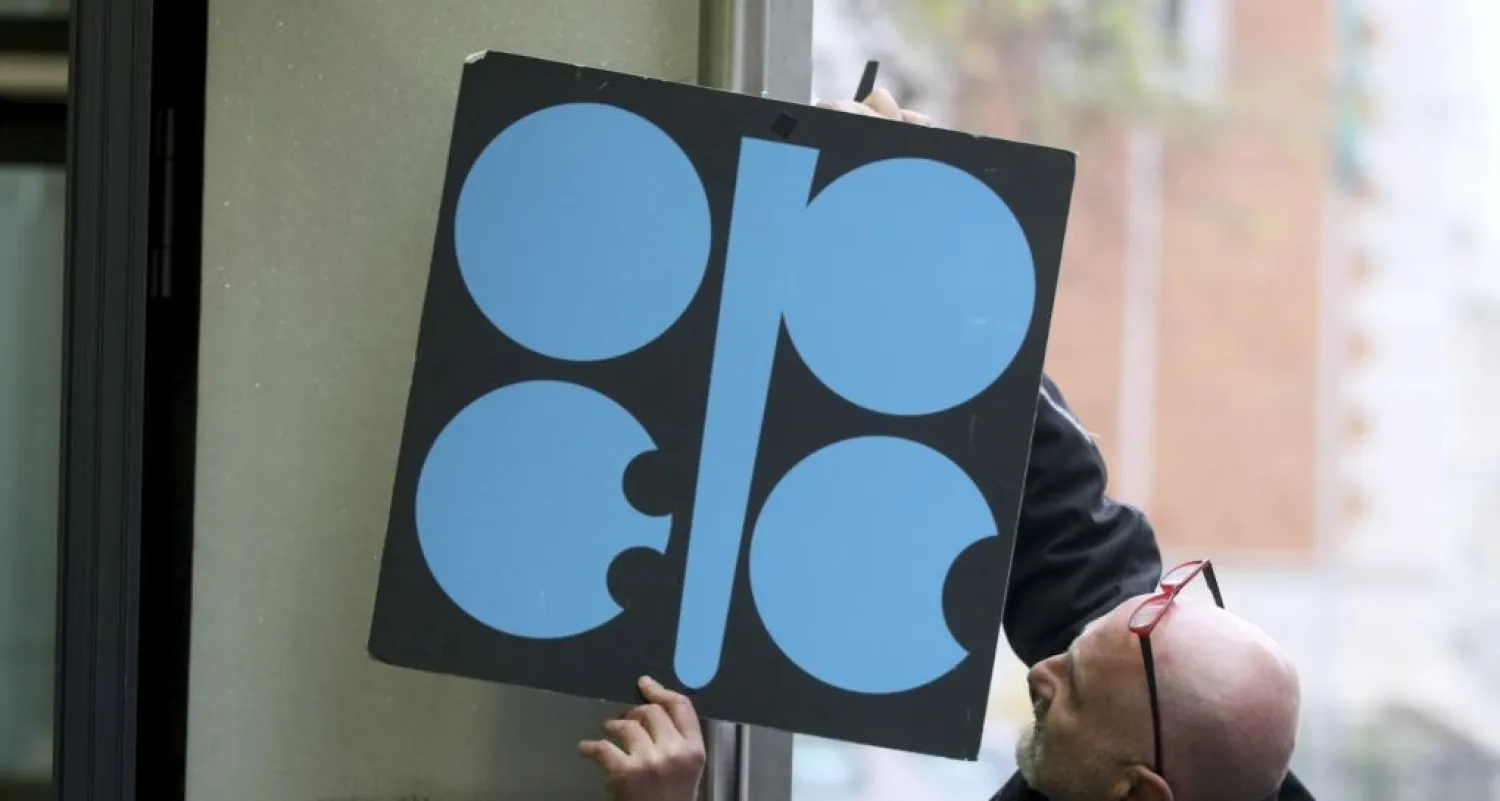 A worker attaches a poster of the Organization of the Petroleum Exporting Countries at its headquarters in Vienna. AP file photo