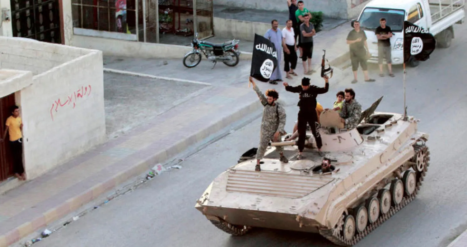 عناصر من «داعش» فوق مدرعة بالرقة يونيو 2014 قبل اندحارهم عن المدينة السورية إلى مناطق أخرى (رويترز)