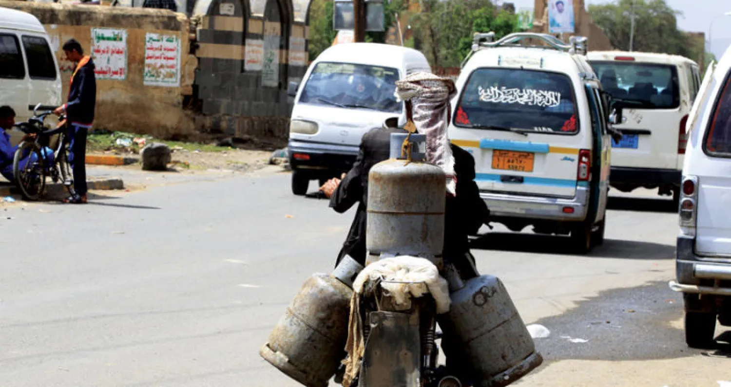 يمني يحمل على دراجته اسطوانات فارغة بحثاً عن الغاز في صنعاء أمس (إ.ب.أ)