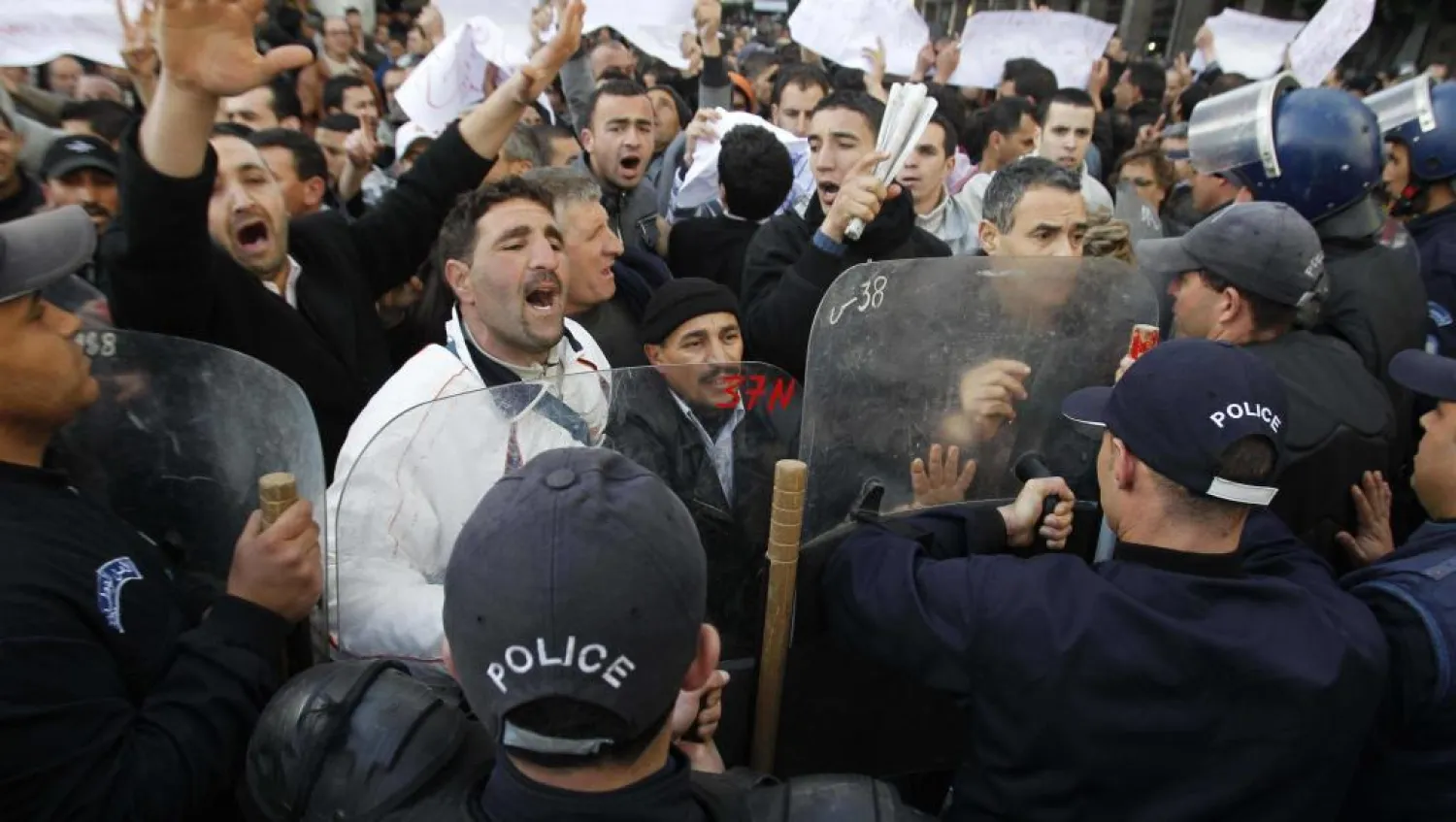 Protesters chant slogans in front of a policeman during a demonstration in Algeria. (Reuters)