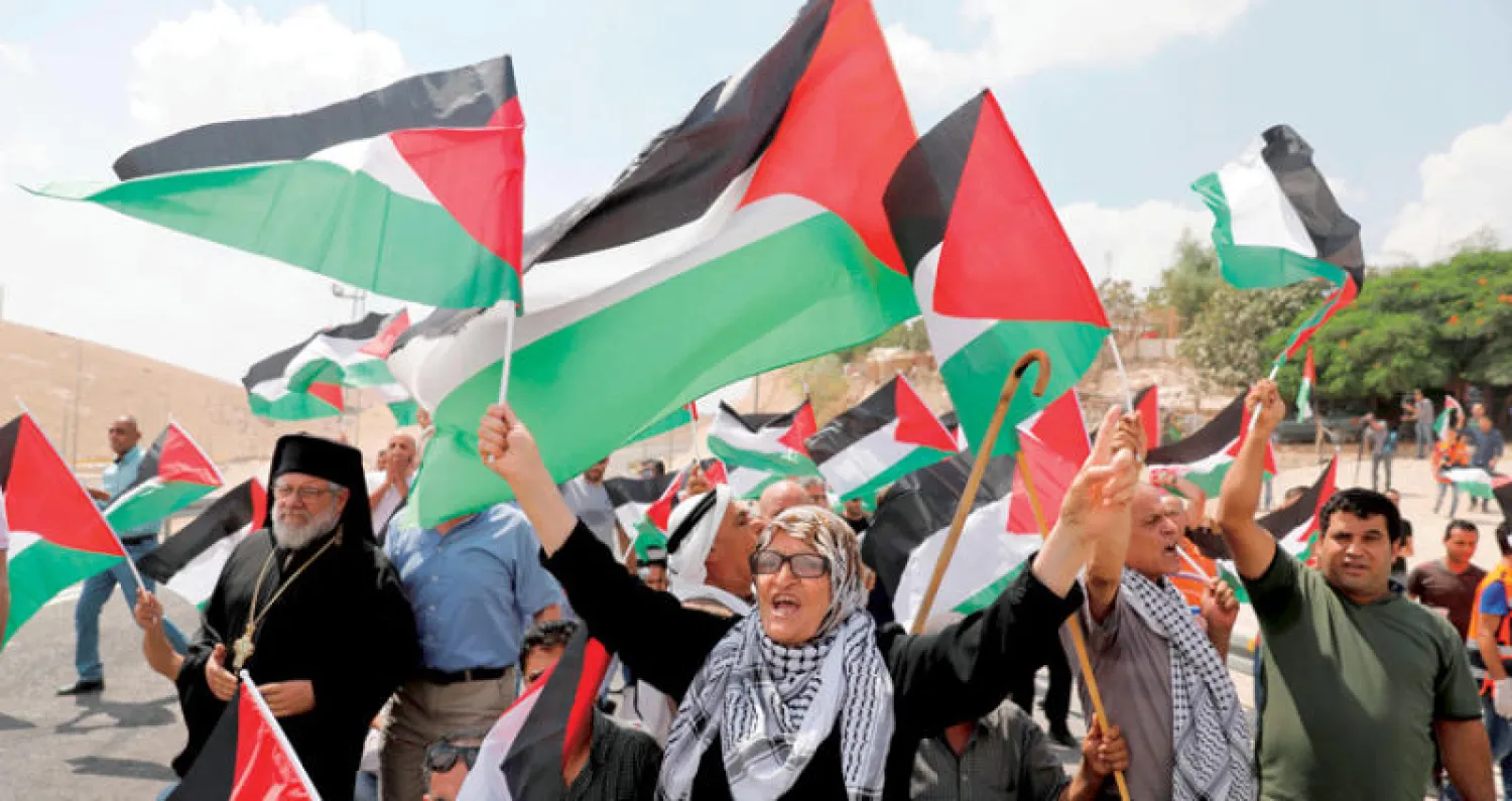 فلسطينيون خلال مظاهرة يوم الجمعة بجوار قرية الخان الأحمر في الضفة تضامناً مع سكانها المهددين بالطرد (أ.ف.ب)