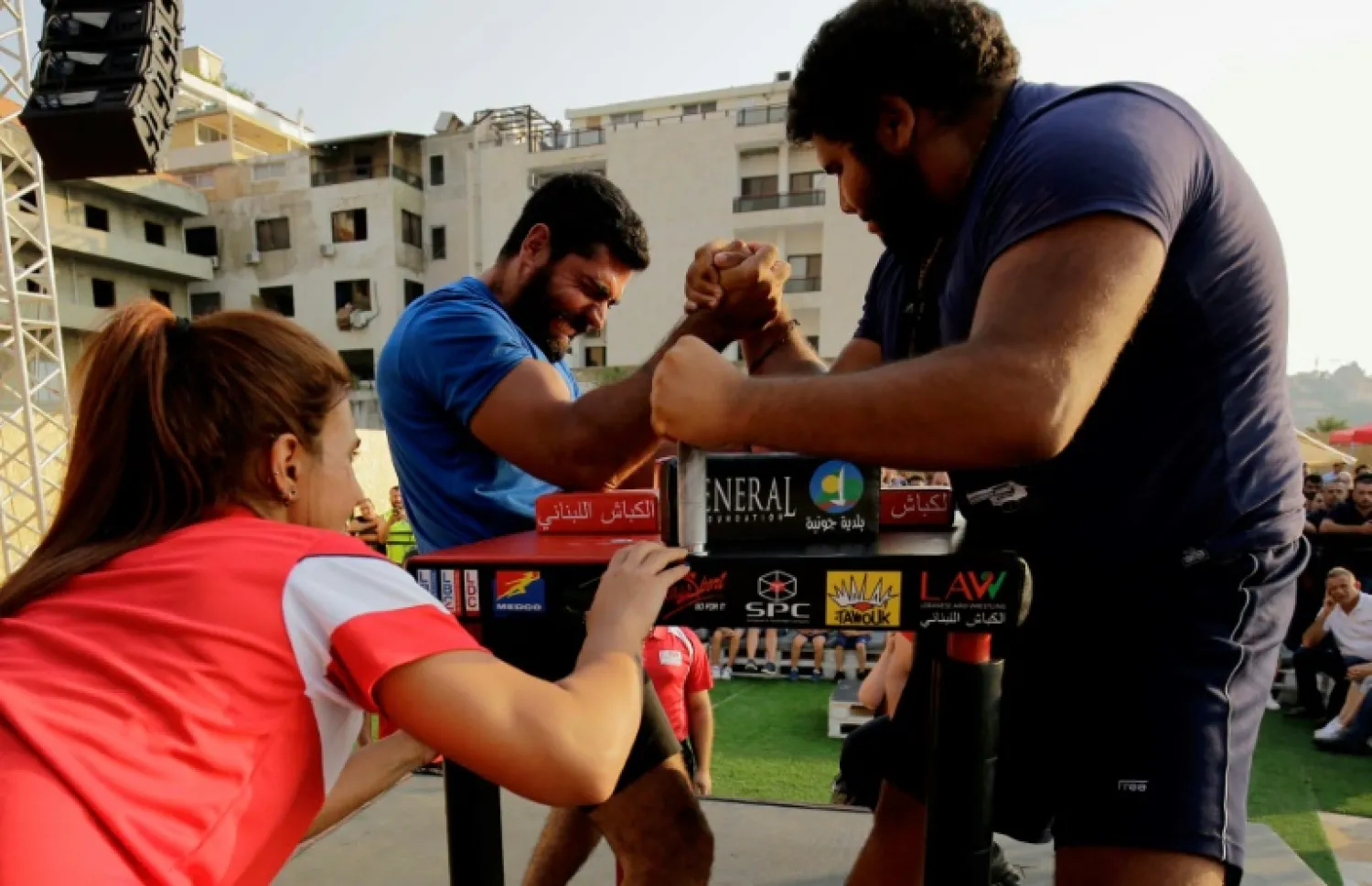 Men compete in an arm wrestling championship in Lebanon's coastal city of Jounieh on July 13, 2018 | AFP