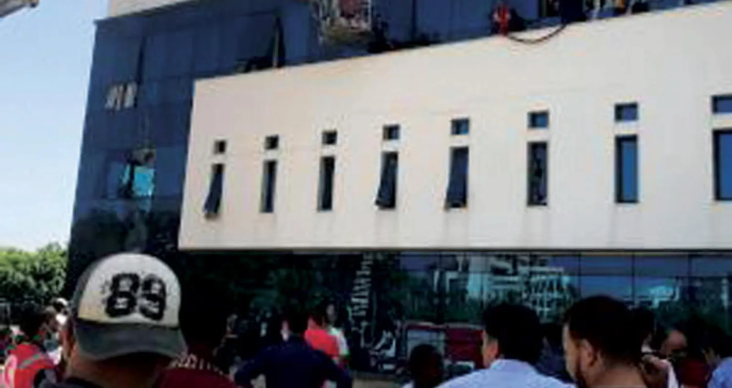 عناصر إطفاء أمام مقر مؤسسة النفط الوطنية الليبية في طرابلس أمس (أ.ف.ب)