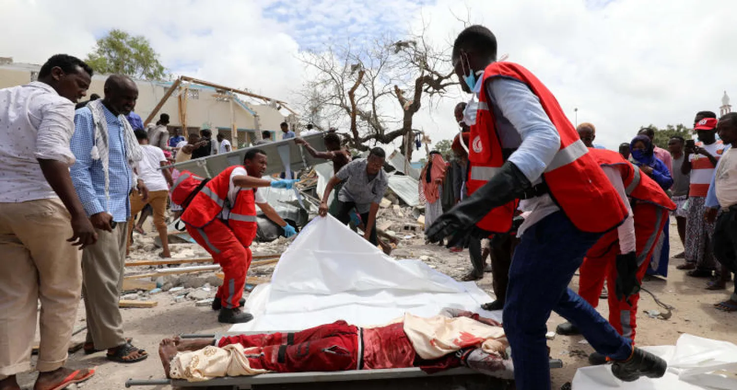 رجال الإنقاذ يستعدون لنقل جثة رجل مجهول من مكان انفجار بمنطقة هودان بمقديشو (رويترز) 