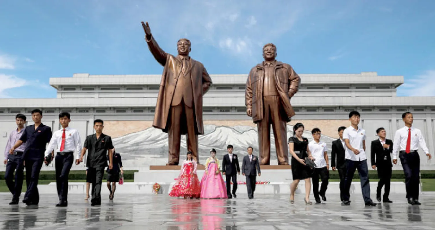 كوريون شماليون يبدون احتراما لتمثالي كيم إيل سونغ وكيم جونغ إيل في بيونغ يانغ أمس (رويترز)