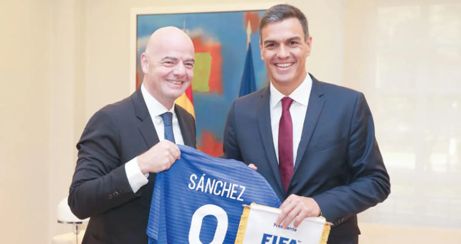 إنفانتينو يسلم رئيس الوزراء الإسباني بيدرو سانشيز قميصاً رمزياً (أ.ف.ب)