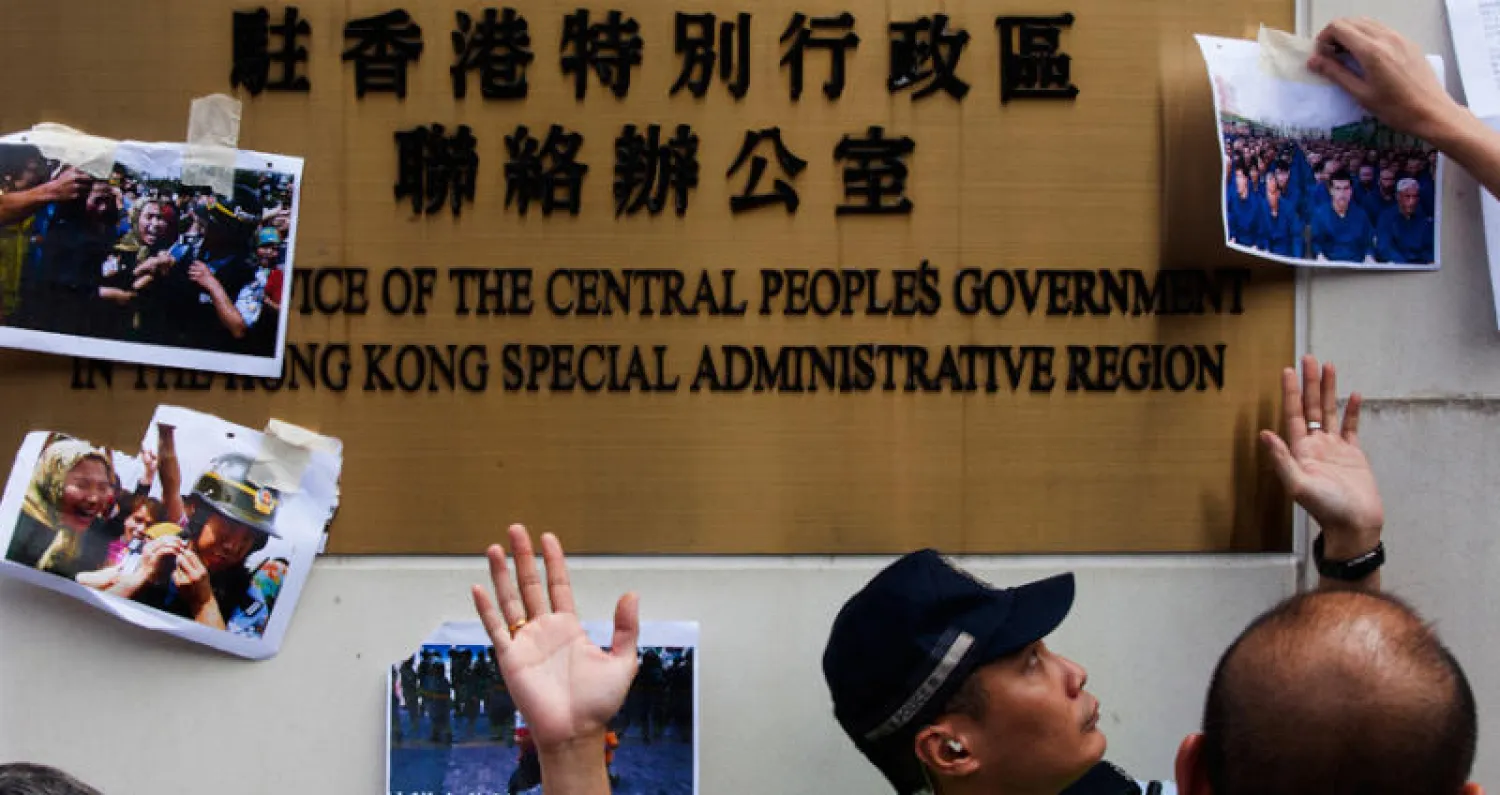 صور رفعها متضامنون مع أقلية الإيغور امام مكتب التنسيق الصيني في هونغ كونغ (إ.ب.أ)