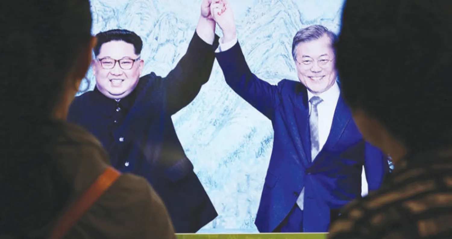 زوار مركز الوحدة على الحدود بين الكوريتين يشاهدون صورة لزعيمي الشطرين خلال قمة سابقة (أ. ب)