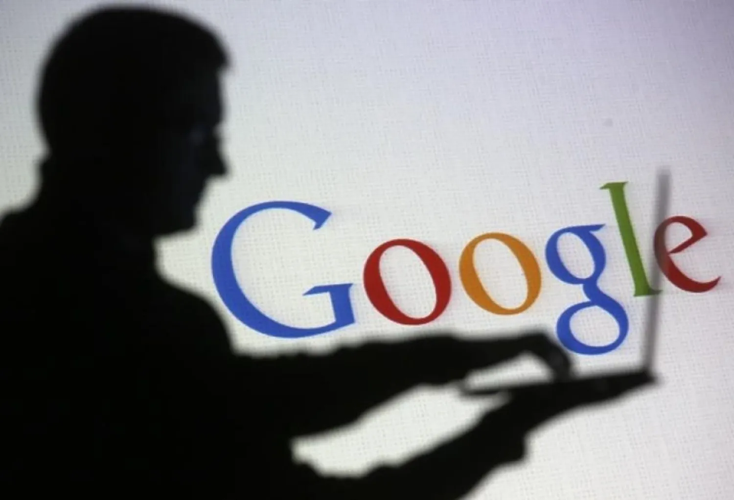 People pose with laptops in front of projection of Google logo
in this picture illustration taken in Zenica. Photo: Reuters