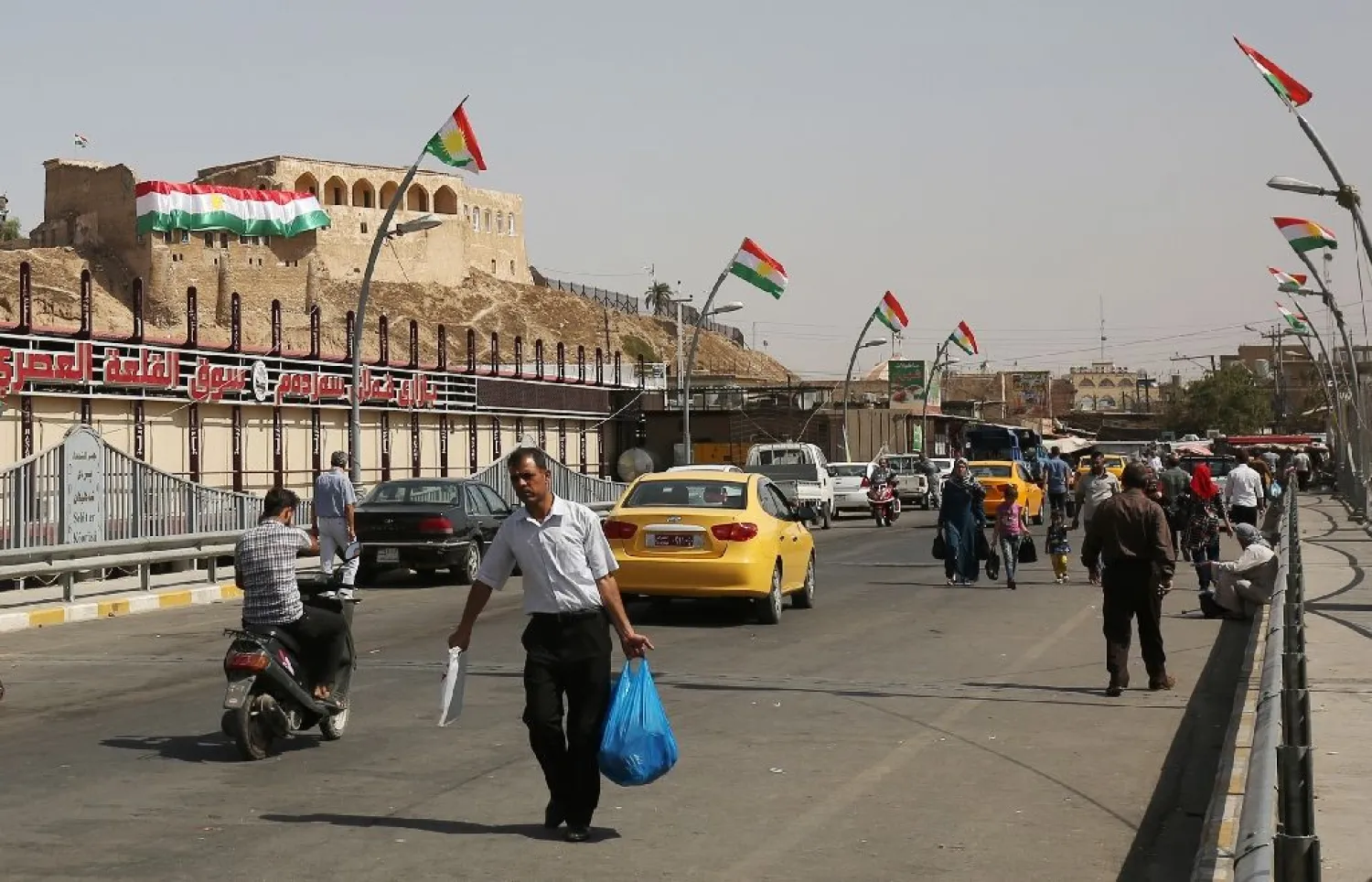 Iraqis walk past Kurdish flags in central Kirkuk on September 24, 2017, on the eve of an independence referendum for the autonomous region of Kurdistan. (AFP)