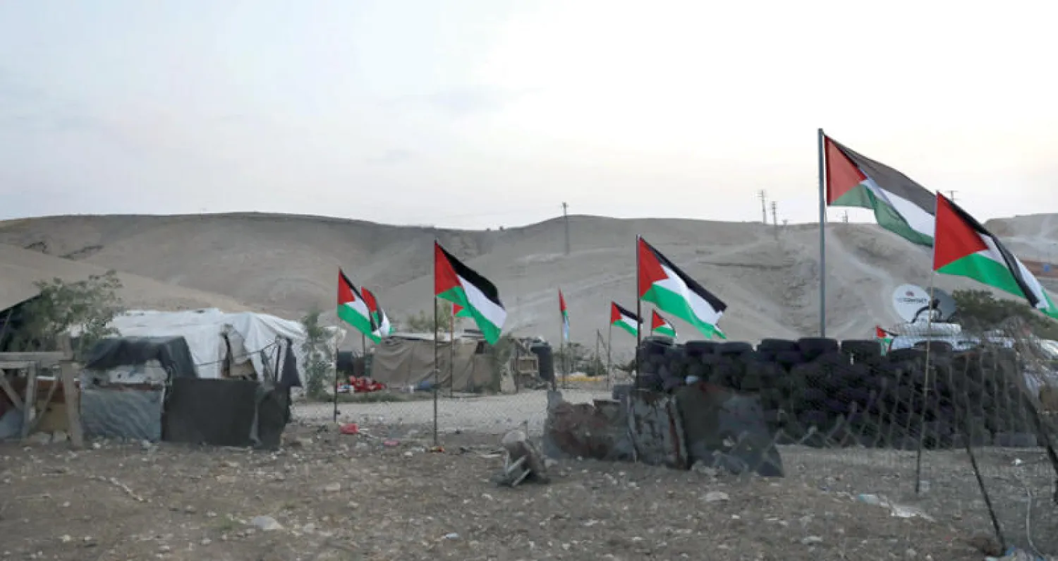 أعلام فلسطينية تزين منطقة الخان الأحمر التي احتشد فيها نشطاء لمواجهة قرار الهدم (أ.ف.ب)