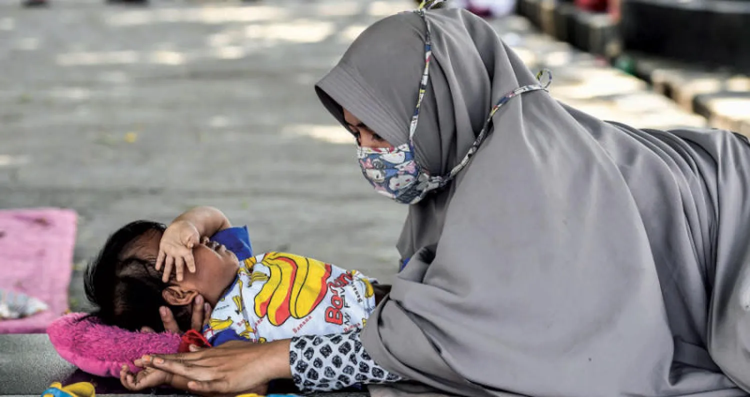 أم تلاعب طفلها في مخيم مؤقت في بالو أمس (أ.ف.ب)