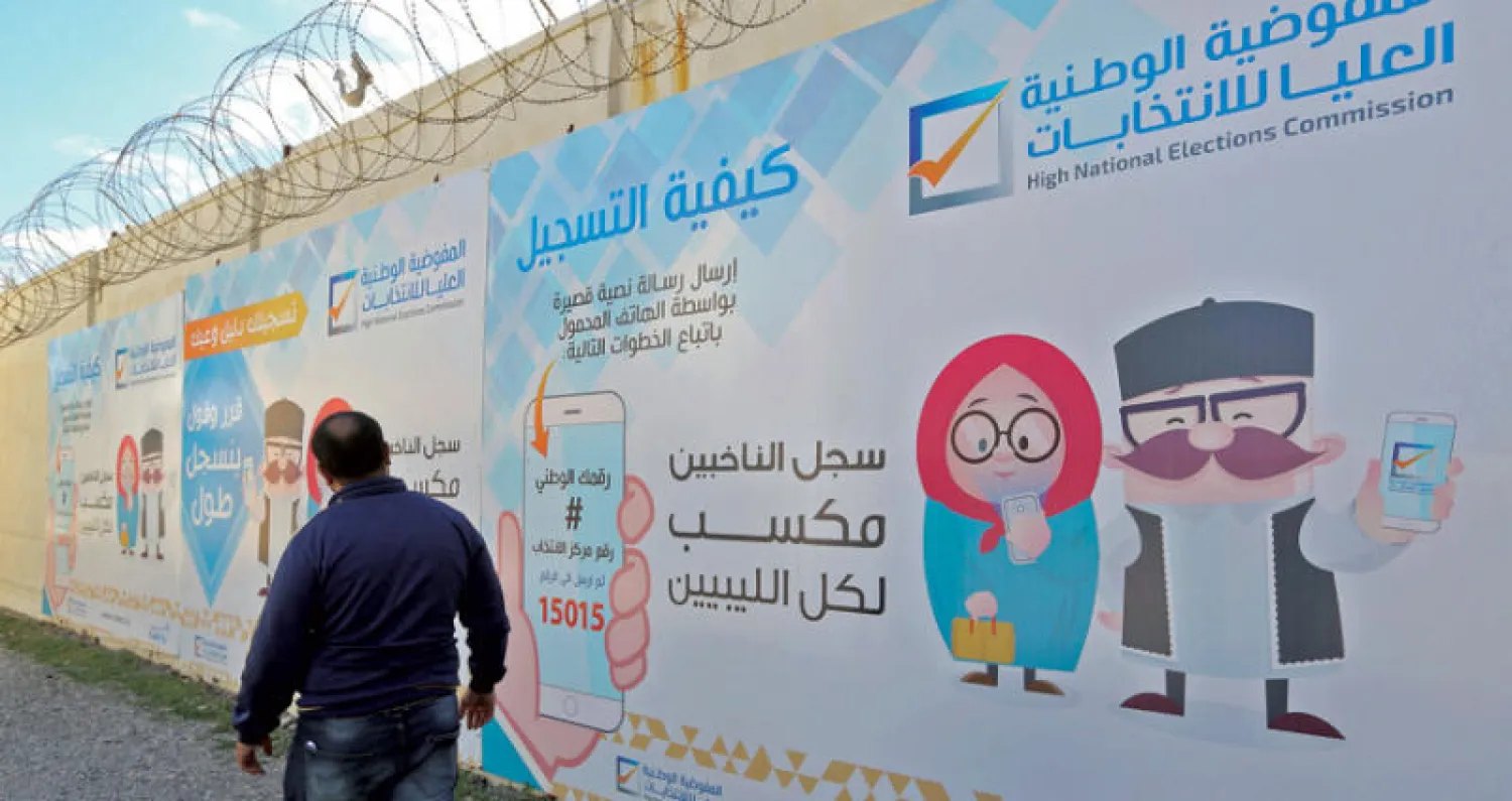 ملصقات تدعو المواطنين إلأى تسجيل أسمائهم في قوائم المنتخبين تحضيراً للانتخابات التي يتوقع أن تشهدها البلاد في ديسمبر المقبل (غيتي)