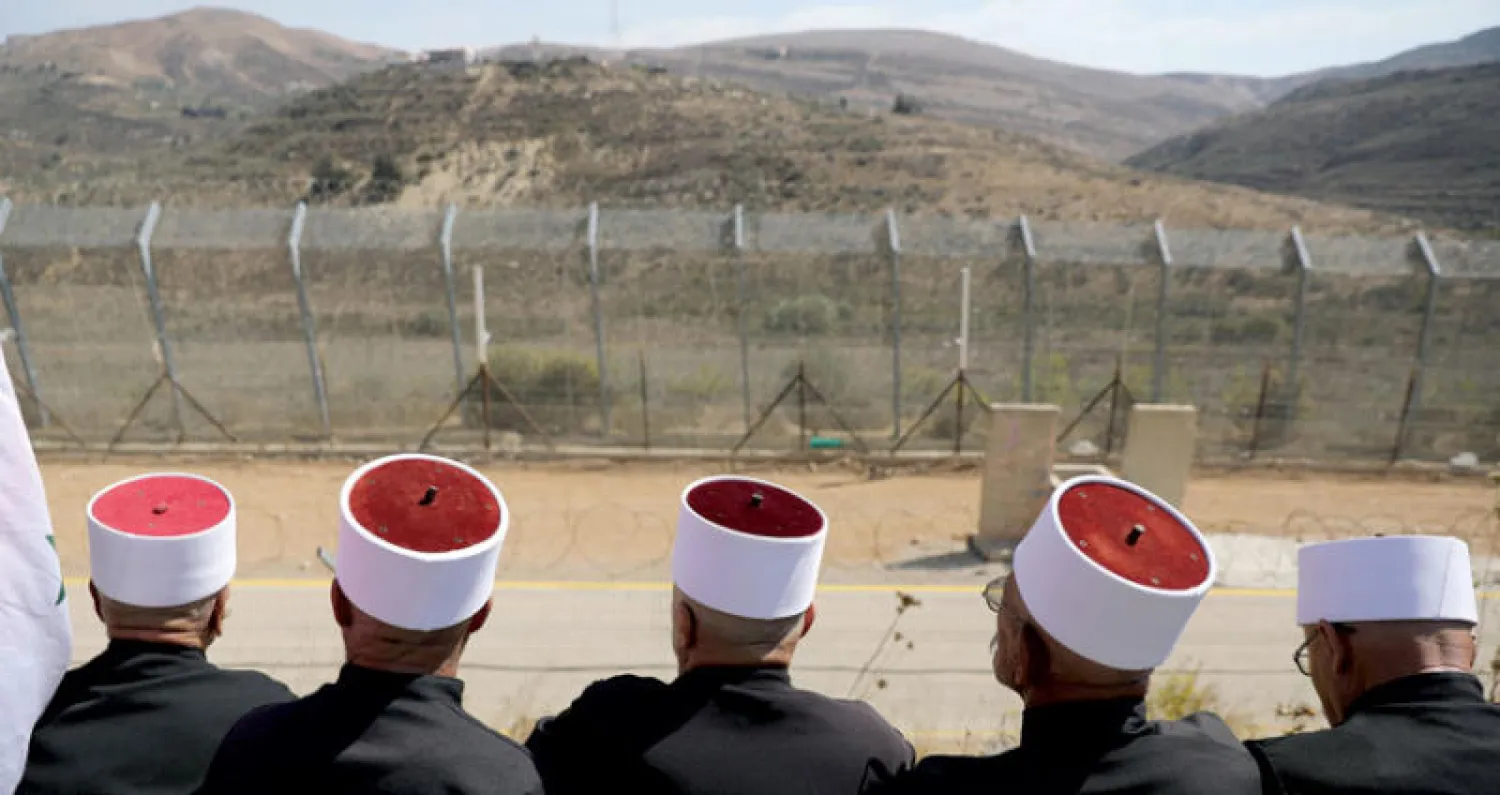 دروز خلال مسيرات أمس في مجدل شمس على خط وقف النار في الجولان المحتل بين سوريا وإسرائيل (رويترز)