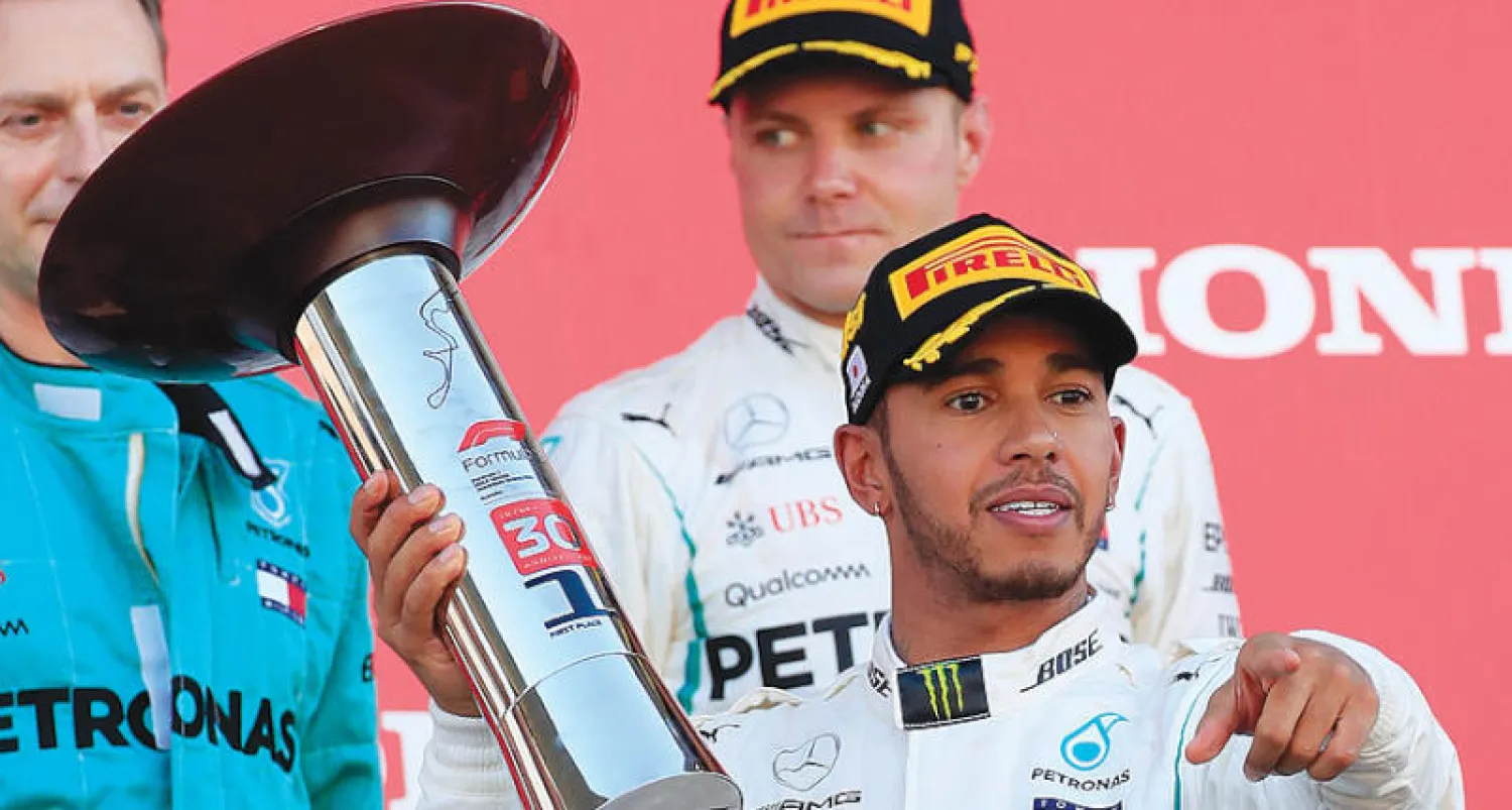 هاميلتون على منصة التتويج اليابانية (إ.ب.أ)