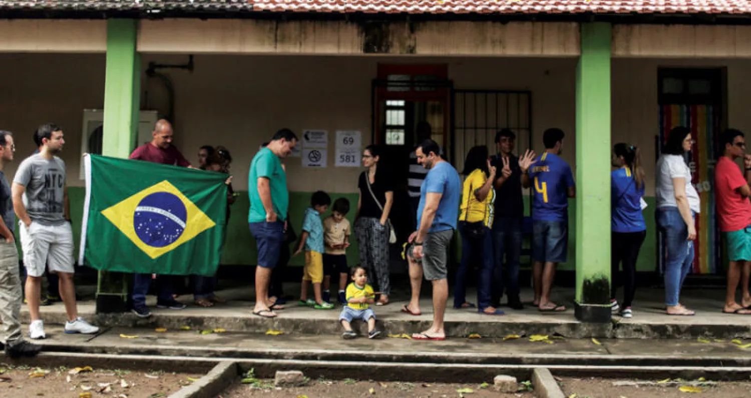 ناخبون برازيليون ينتظرون دورهم للتصويت في ريو دي جانيرو أمس (إ.ب.أ)