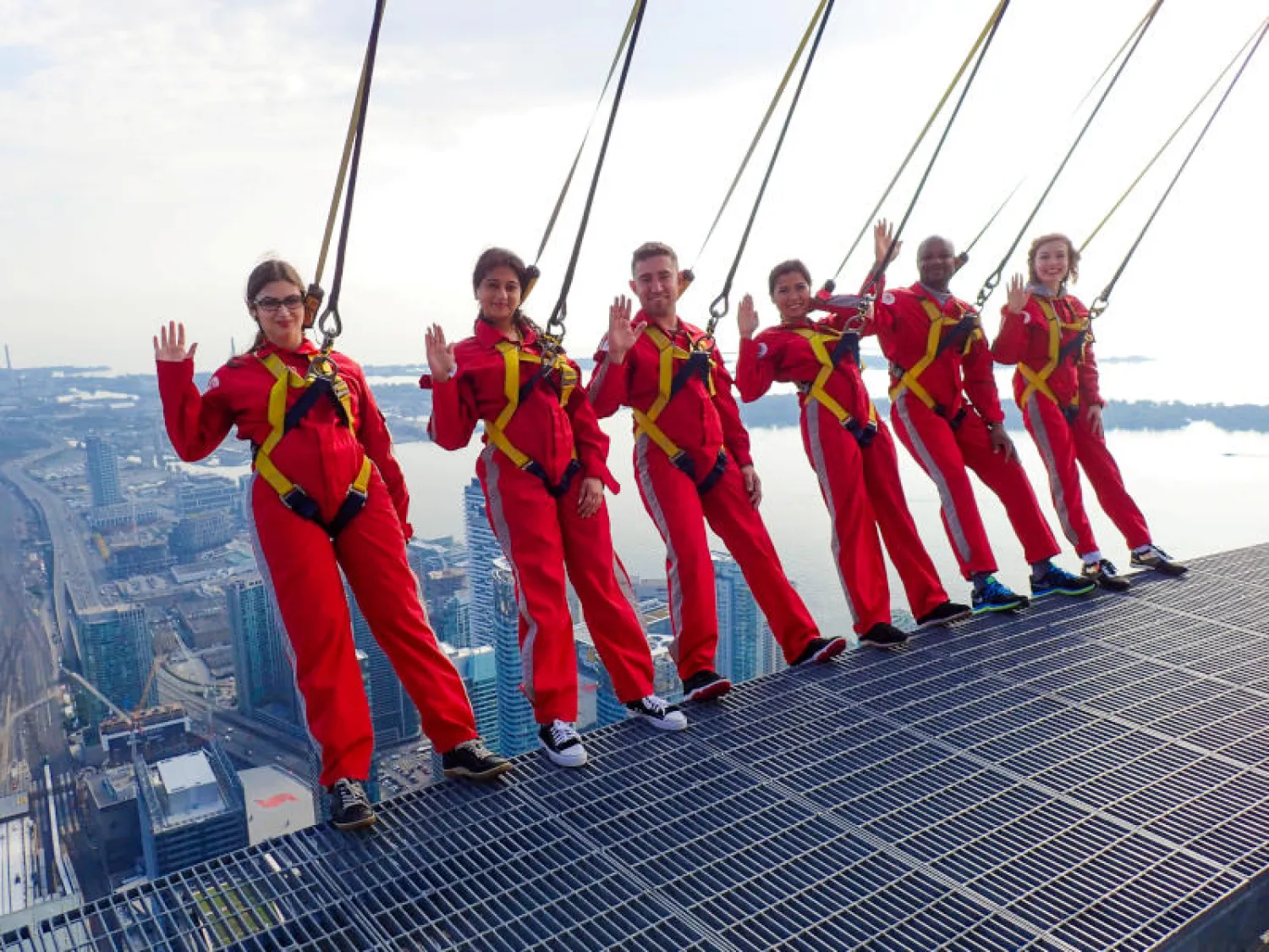 ستة مواطنين جدد يؤدون قسم الحصول على الجنسية الكندية على حافة أحد أعلى المباني في العالم وسط مدينة تورنتو (رويترز)