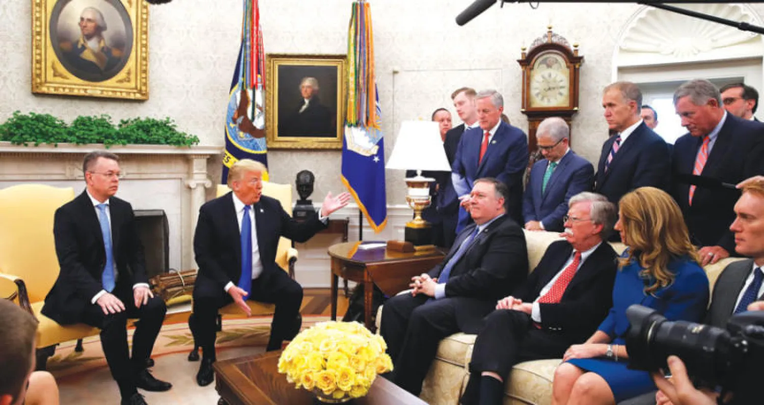 الرئيس دونالد ترمب مستقبلاً القس برانسون في المكتب البيضاوي بالبيت الأبيض بحضور كبار مسؤولي الإدارة الأميركية (أ.ب)