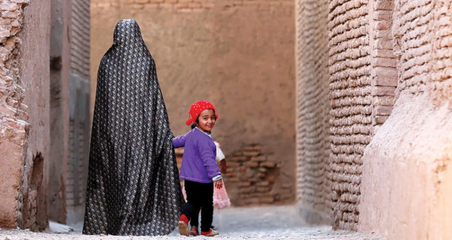 أفغانية وطفلتها في الحي القديم بمدينة هرات في غرب أفغانستان أمس (رويترز)