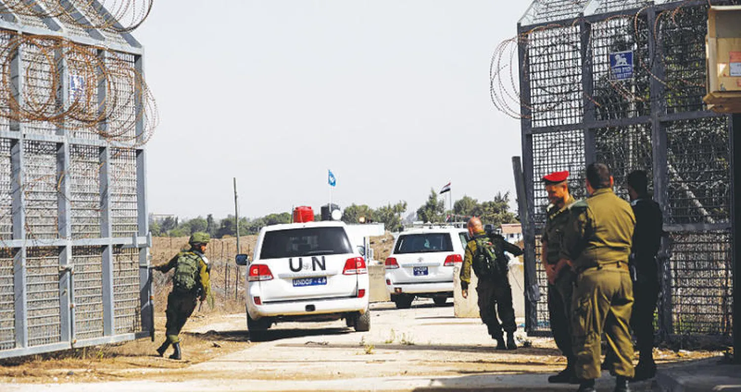 سيارتان تابعتان للأمم المتحدة تعبران معبر القنيطرة في الجولان أمس (رويترز)