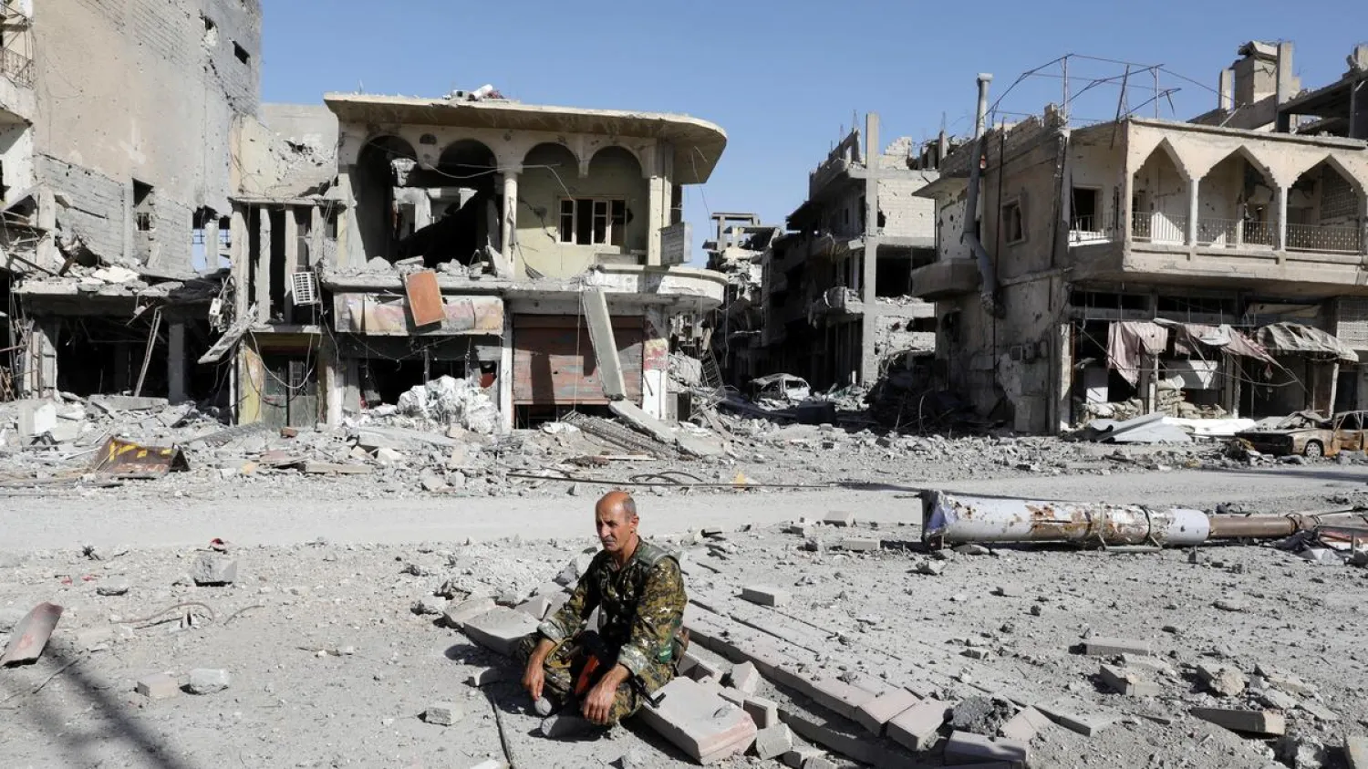 An SDF fighter rests on rubble after Raqqa was liberated. (Reuters)
