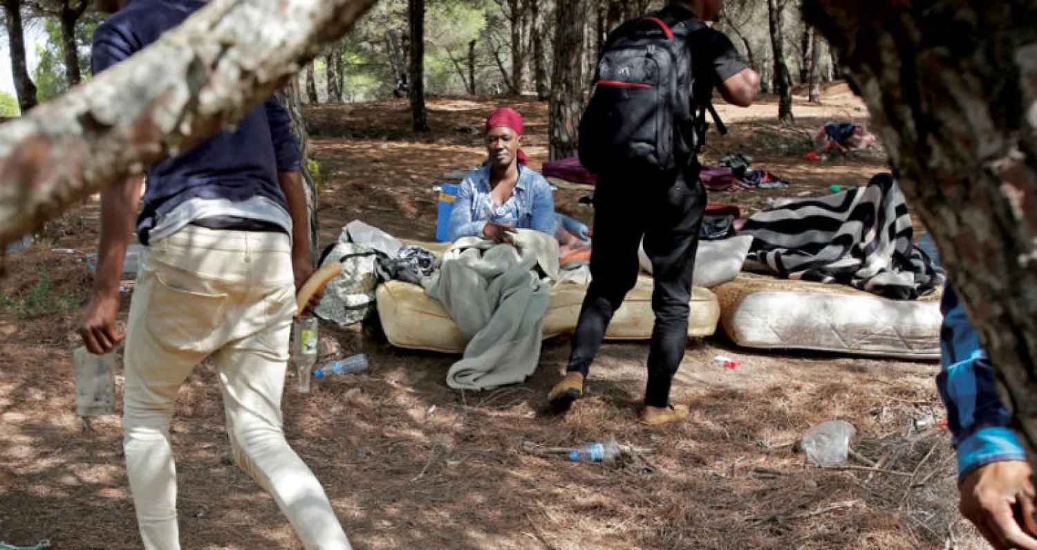 مهاجرون أفارقة في مخيم مؤقت بمنطقة جبلية قريباً من طنجة بالمغرب (رويترز)