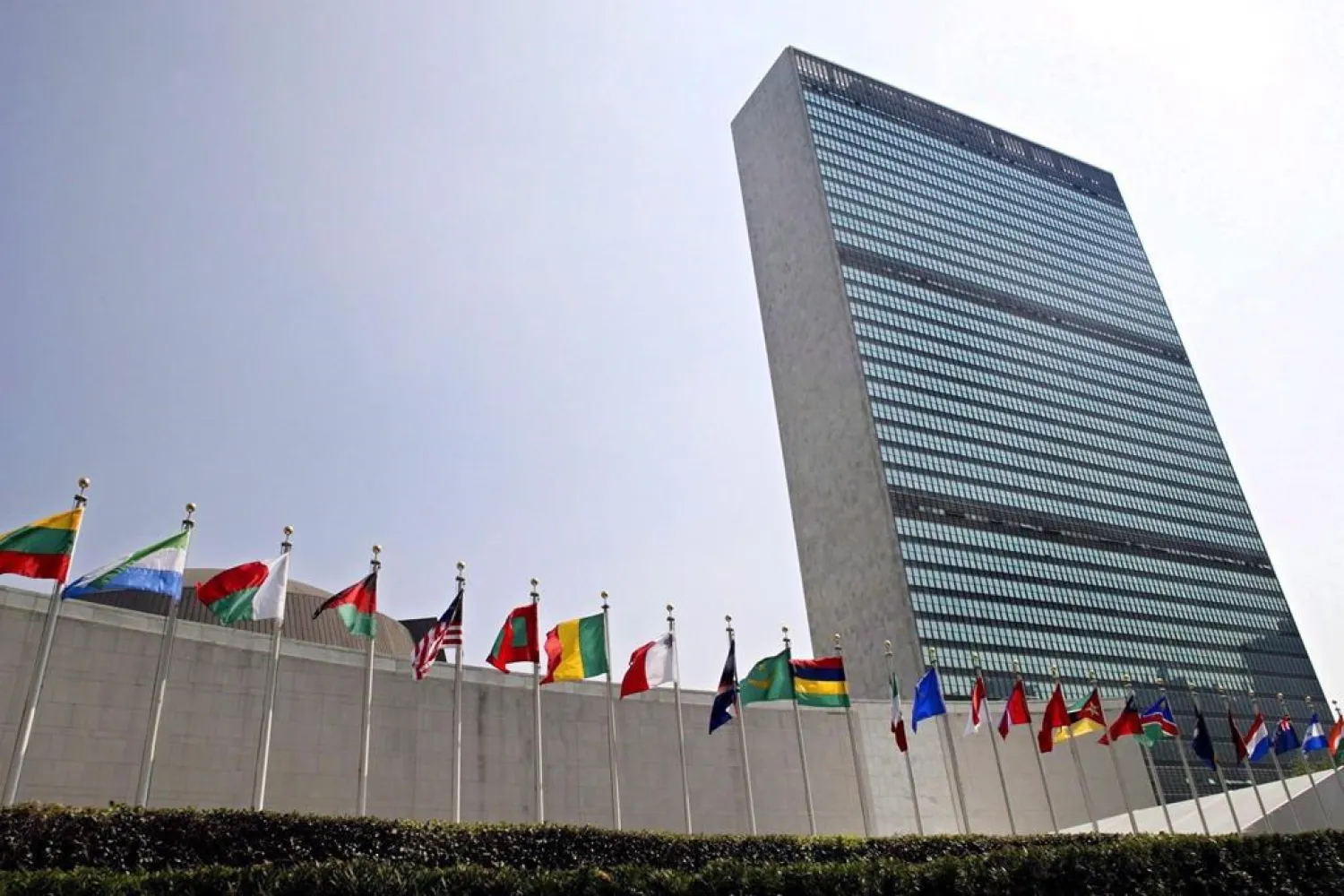 The flags of member nations fly outside the General Assembly building at the United Nations headquarters in New York. (Adam Rountree/AP)