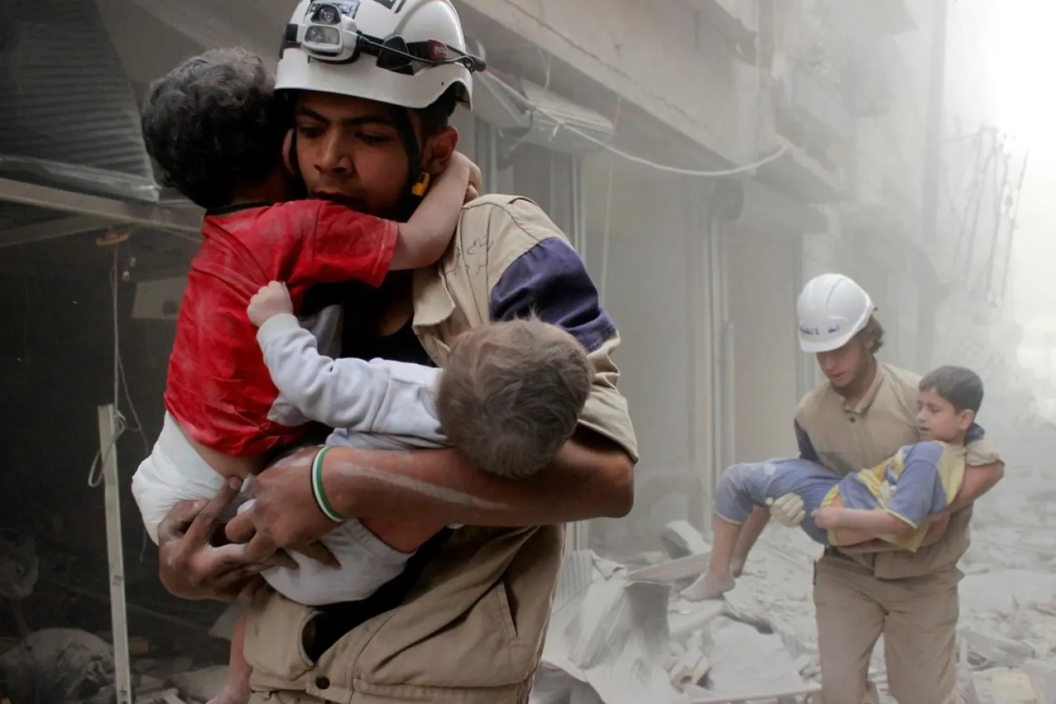 Members of the Civil Defense rescue children after what activists said was an air strike by forces loyal to Assad in al-Shaar neighborhood of Aleppo, Syria June 2, 2014. REUTERS/Sultan Kitaz