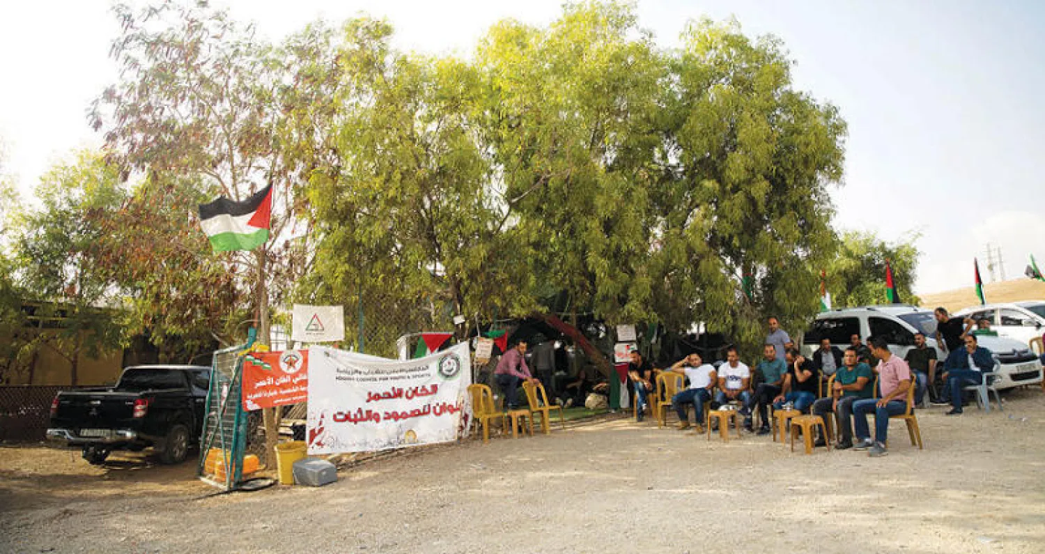 نشطاء فلسطينيون أمام خيمة الاعتصام في قرية الخان الأحمر البدوية بالضفة الغربية (أ.ب)
