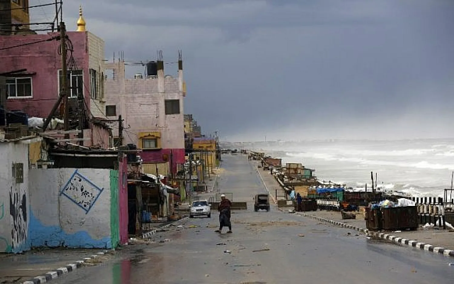 A Palestinian man walks along the beach next to al-Shatee refugee camp on a rainy day, in Gaza City, on February 22, 2016. AFP/MOHAMMED ABED

 