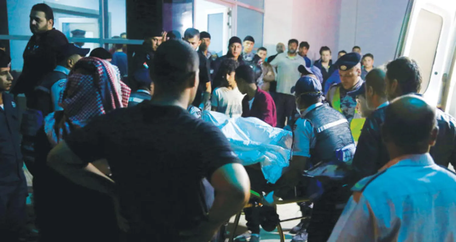 سكان وأقارب لضحايا السيول يتجمعون خارج مستشفى قرب البحر الميت غرب الأردن أمس (رويترز)