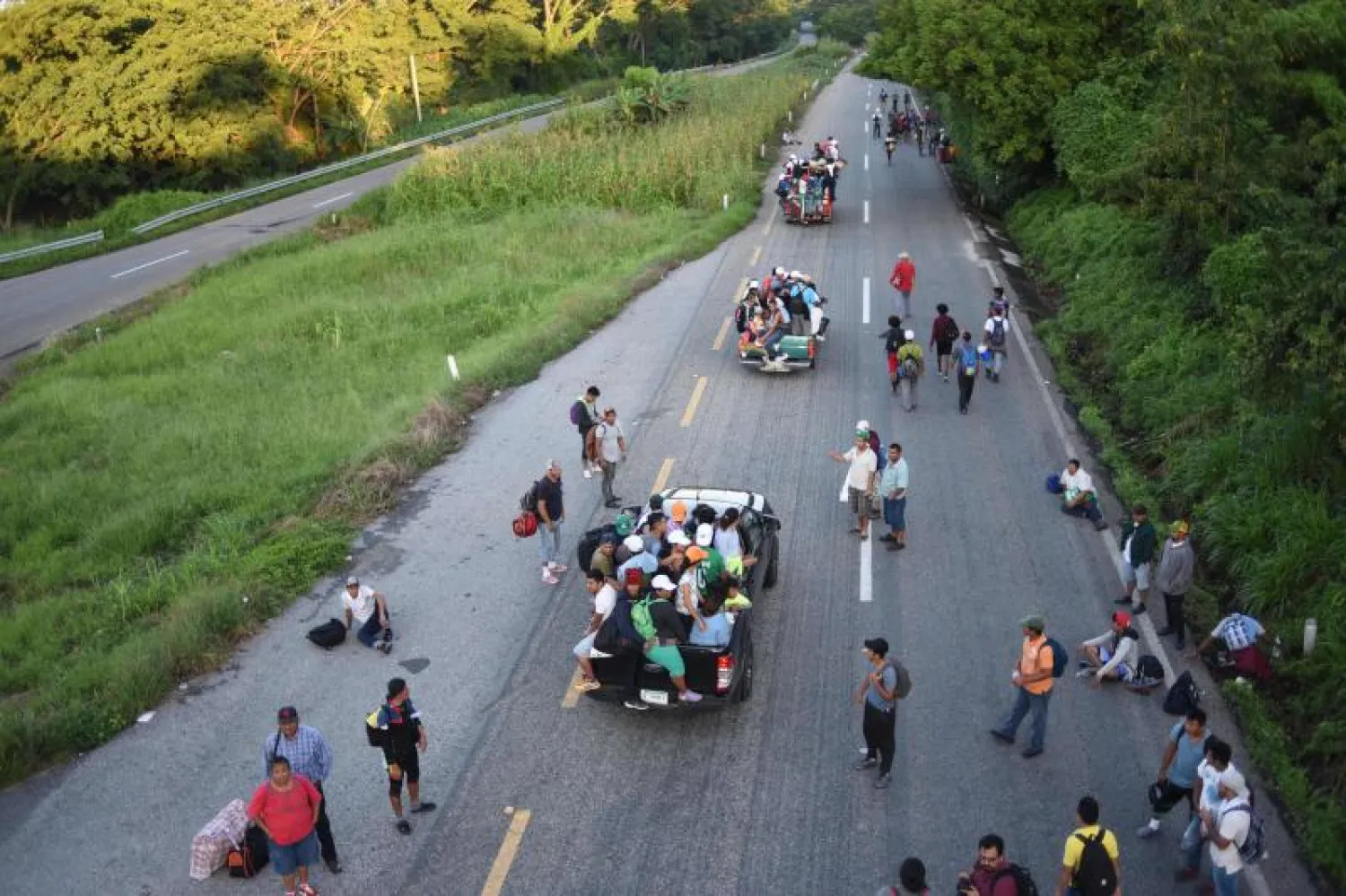 مهاجرون من هندوراس على طريق في بلدة ماباستيبيك المكسيكية يتّجهون إلى الحدود مع الولايات المتحدة (أ. ف. ب)