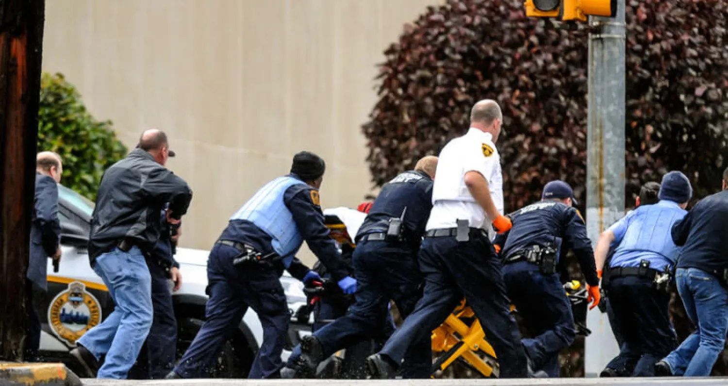 عناصر أمن ينقلون أحد المصابين من المعبد اليهودي  (أ.ب)