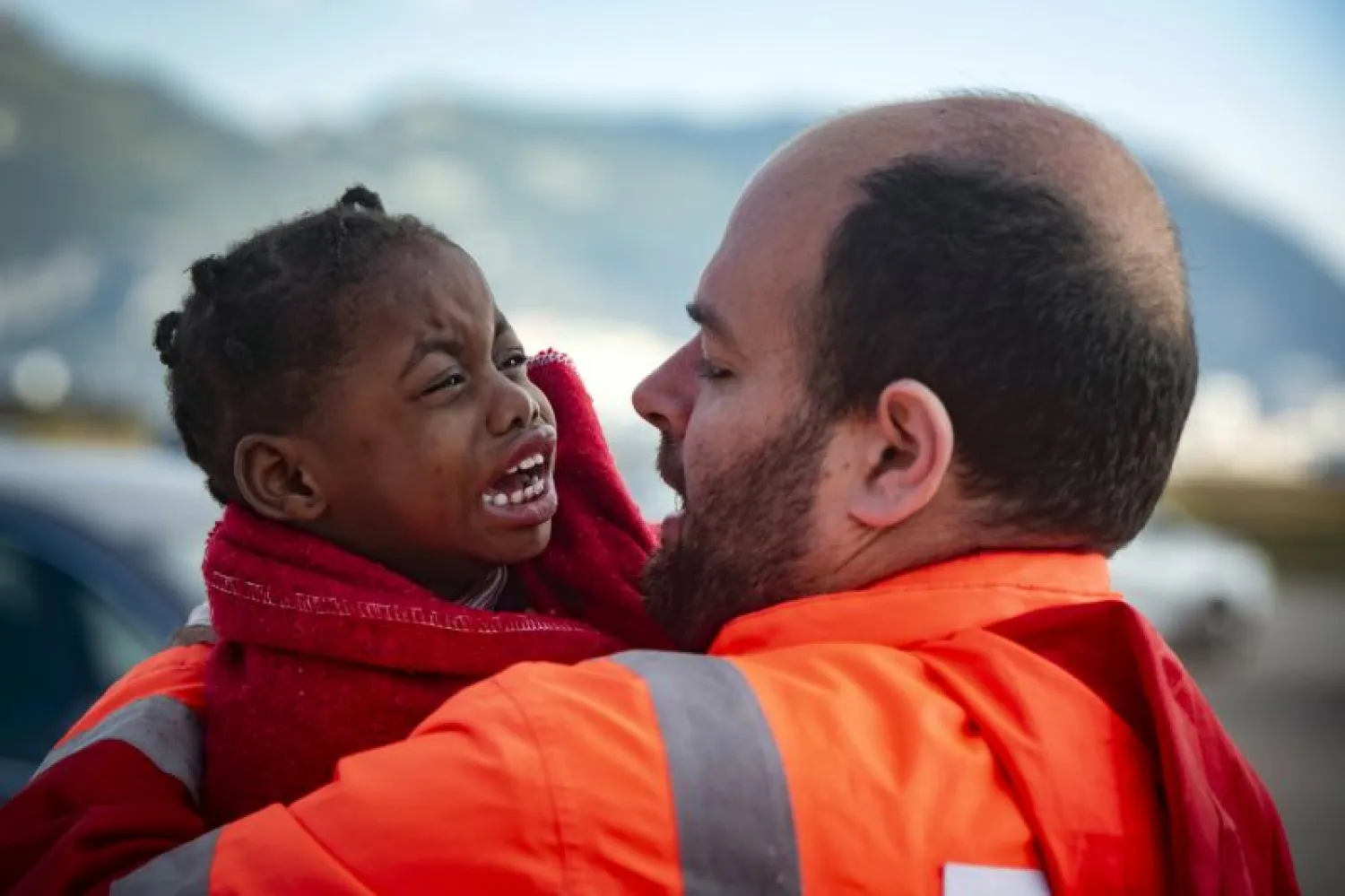 In this photo taken on Saturday, Oct. 27, 2018, a child is carried by a member of Spain's Maritime Rescue Service as they arrive at the port of San Roque, southern Spain, after being rescued by Spain's Maritime Rescue Service in the Strait of Gibraltar. (AP Photo/Marcos Moreno)