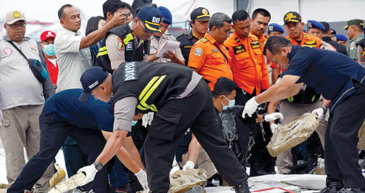 عمال الإغاثة يجمعون مقتنيات عائدة للضحايا من ملابس وأحذية ومحفظات (رويترز)