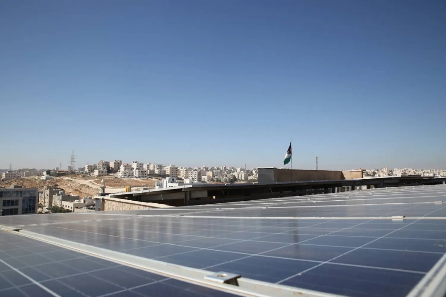 Solar panels look out across Amman city from the roof of the Al Hoffaz school in Amman, Jordan. (Thomson Reuters Foundation)